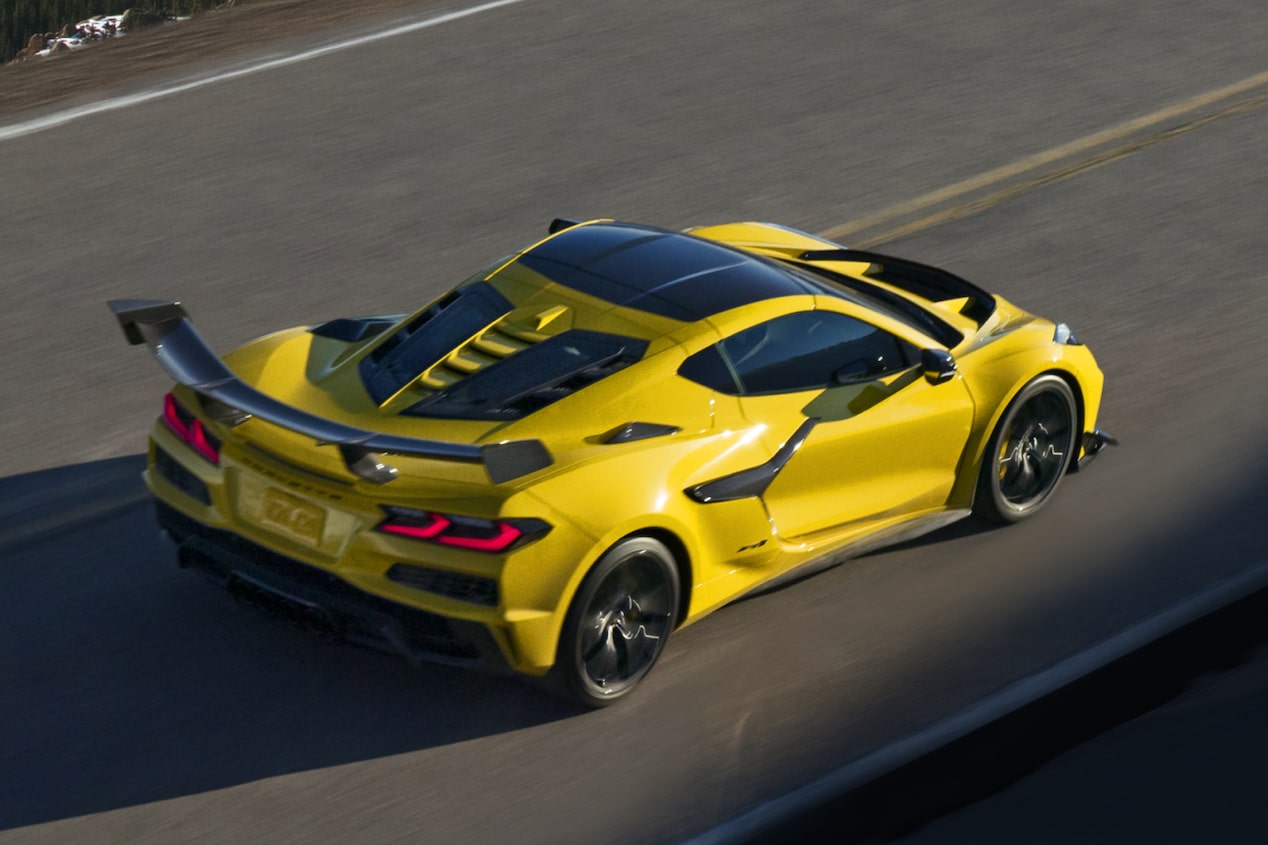 Yellow Chevrolet Corvette with a rear wing on an open road